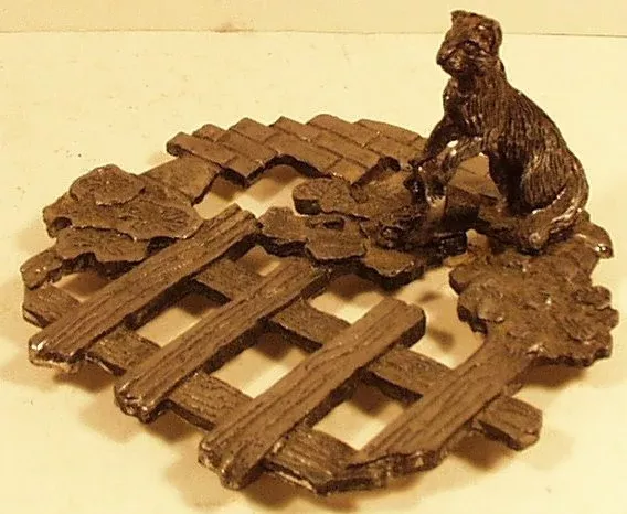 Metal trivet w/ cat spilling bucket dated 1986 Etzke